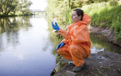 Expert taking water sample from the water stream