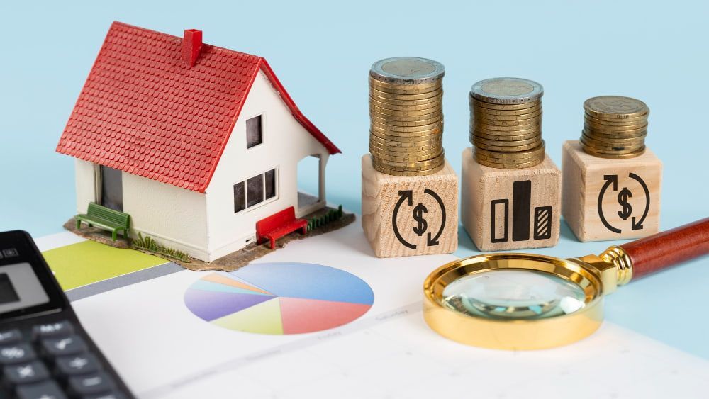 Mini house, coins, magnifier, and chart suggest real estate investment and financial planning.