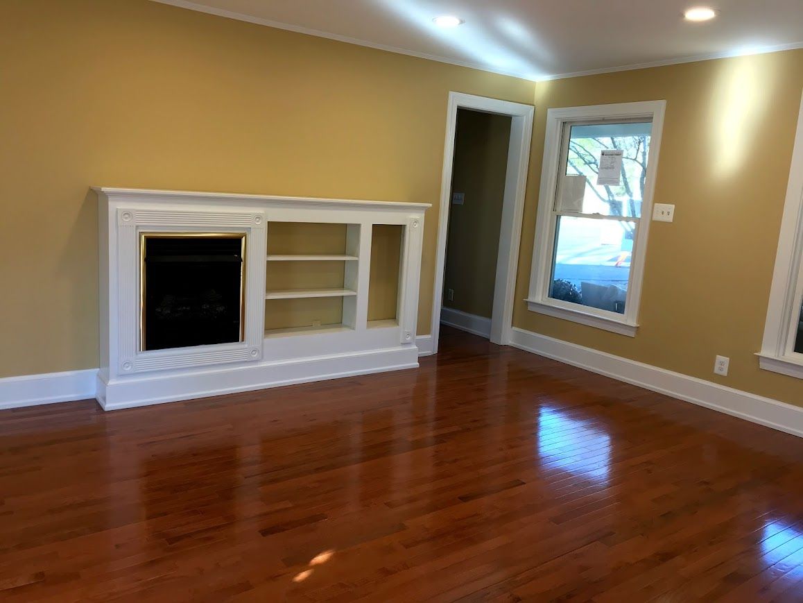 Living room with hardwood floors, a fireplace, and yellow walls.