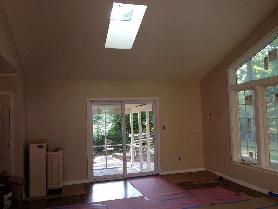 Interior of room with skylight, sliding glass doors, and window; walls are beige.