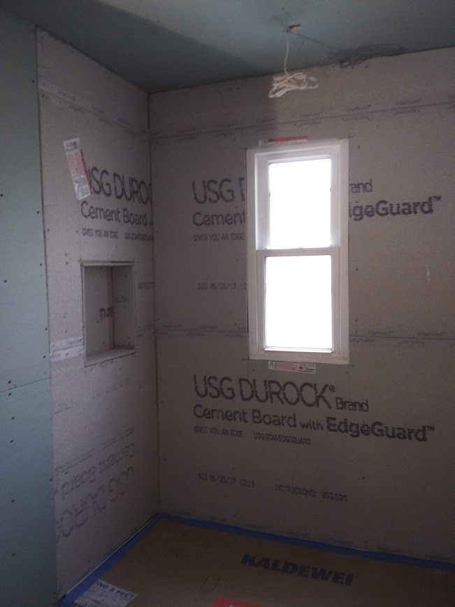Bathroom interior with Durock cement board walls, window, and recessed shelf.