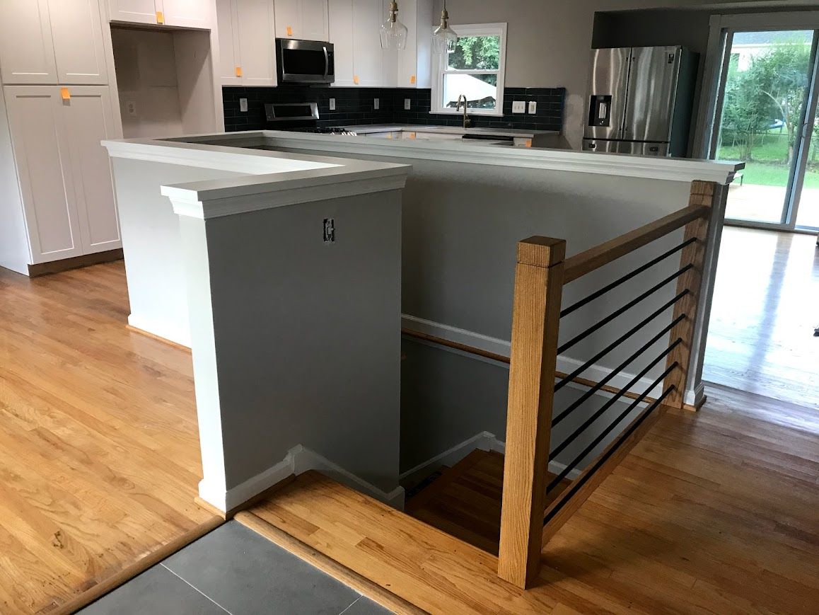 Kitchen remodel with multi-level island, wood floors, and cable railing for a lower level.