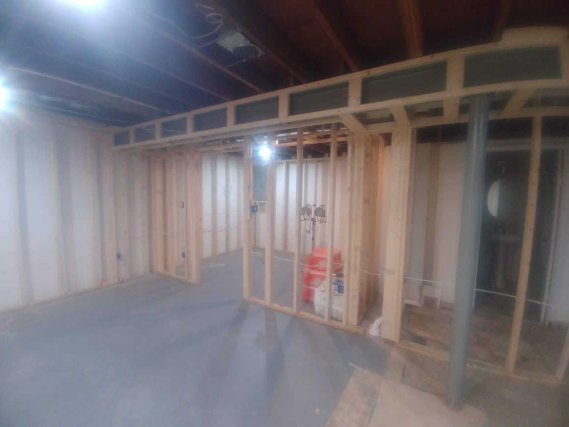 Basement framed for room and utility space, plumbing visible, unfinished construction.