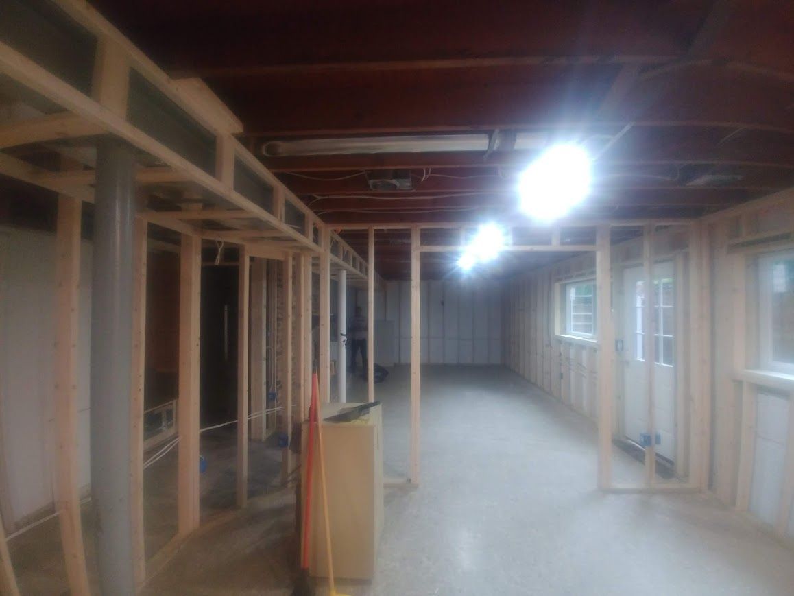 Basement renovation in progress; wooden framing and concrete floor.