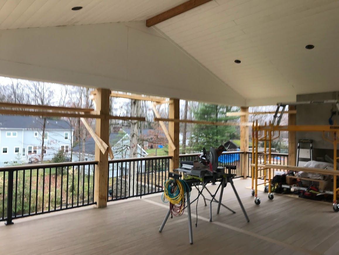 Deck under construction, covered by white ceiling. Saw, scaffolding, and wood beams are visible.