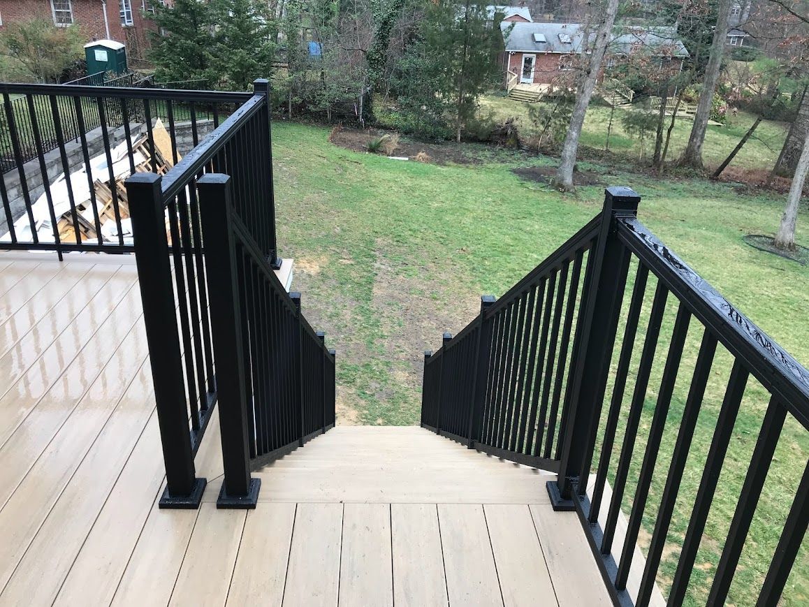 Deck with black railings and steps leading to a grassy yard.