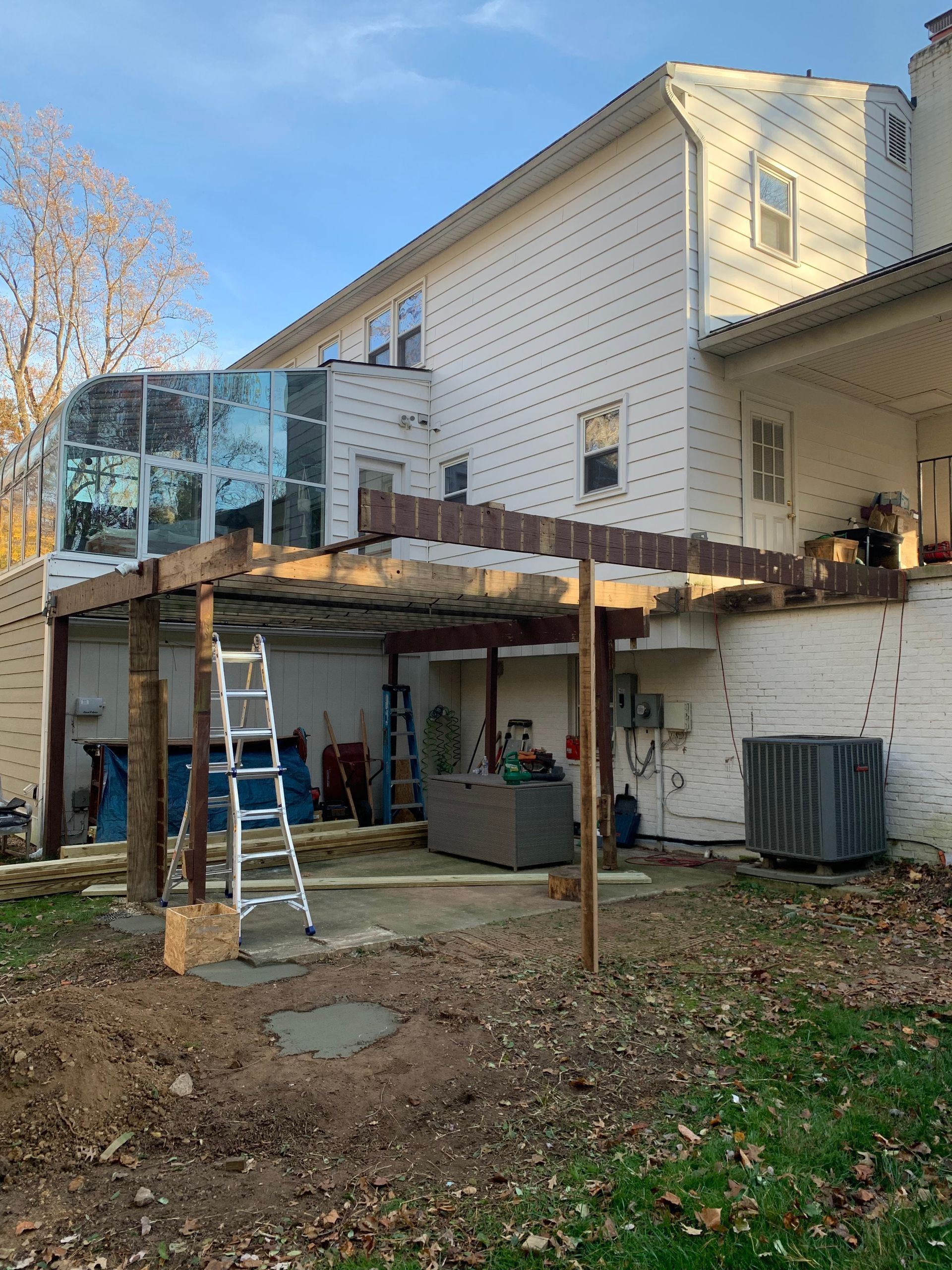 Backyard deck under construction; includes ladder, supports, and partly finished structure.