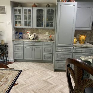 A kitchen with gray cabinets and a herringbone floor.