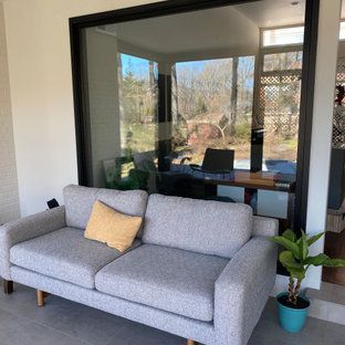 A couch is sitting in front of a large window in a living room.