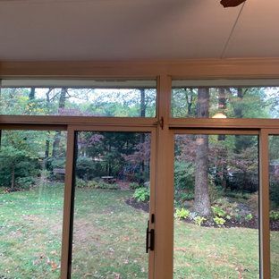A sun room with sliding glass doors and a ceiling fan.
