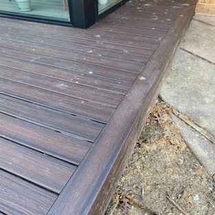 A close up of a wooden deck with a window in the background.