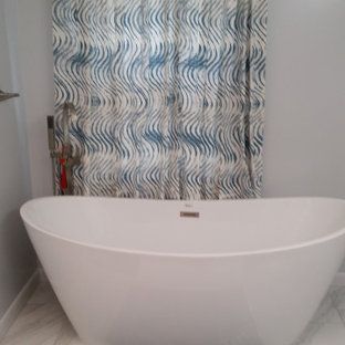 A white bathtub is sitting in a bathroom next to a shower curtain.