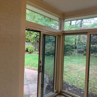 A sun room with sliding glass doors leading to a backyard.