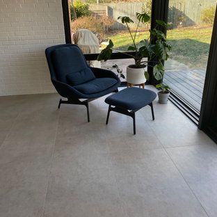 A chair and ottoman are sitting in a living room next to a window.