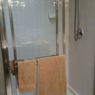 Two towels are hanging on a towel rack in a bathroom next to a shower stall.