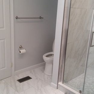 A bathroom with a toilet , shower , and towel rack.