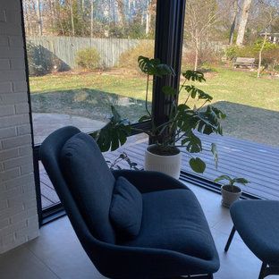 A chair and ottoman are sitting in front of a window in a living room.