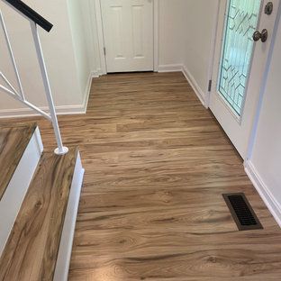 A hallway with hardwood floors and stairs in a house.