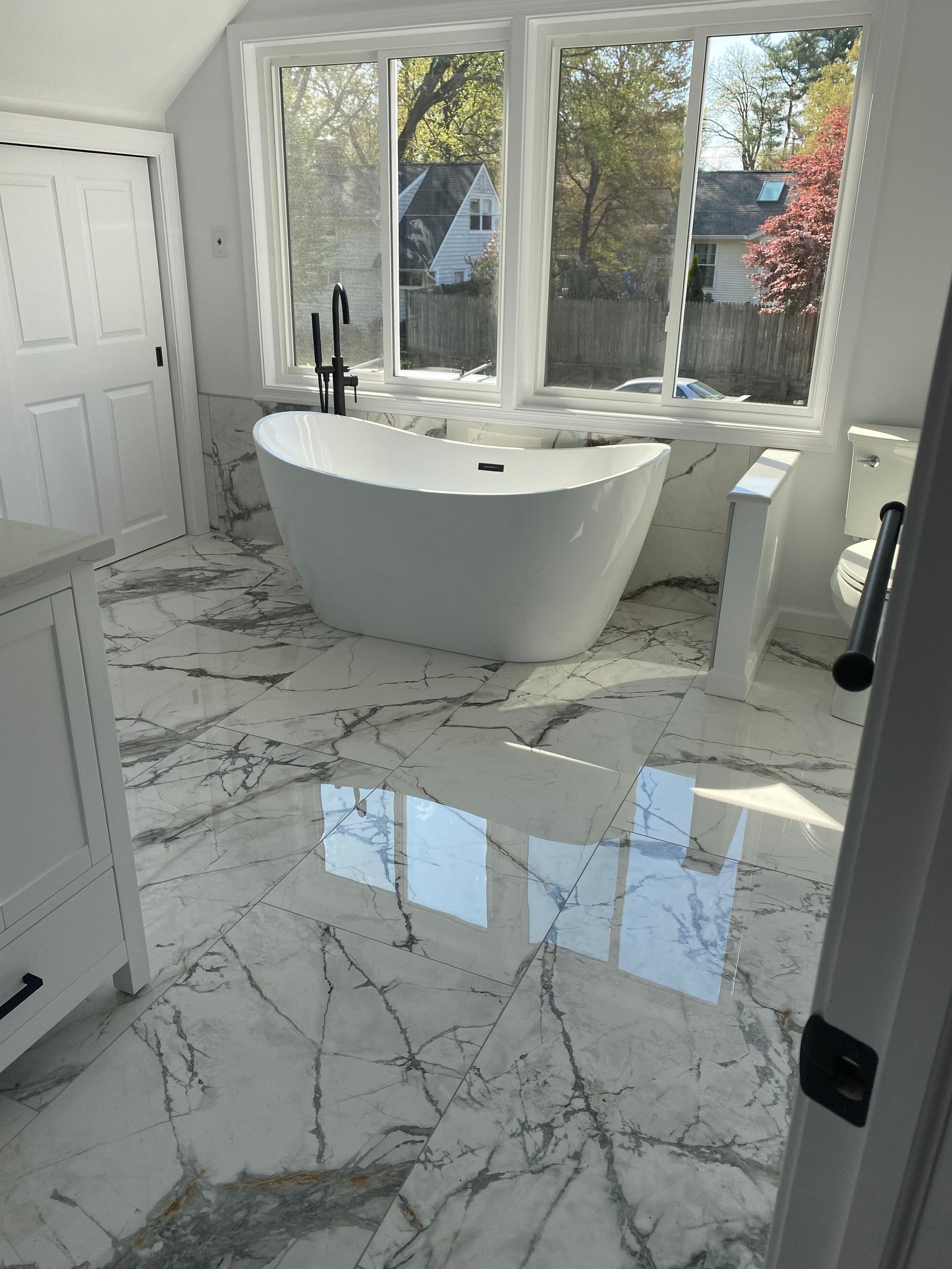 A bathroom with a bathtub and a marble floor.
