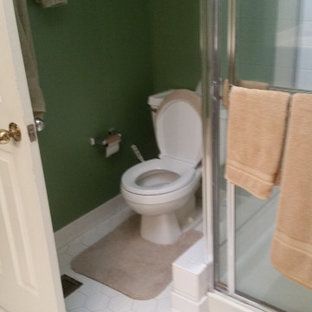 A bathroom with a toilet and a shower stall.