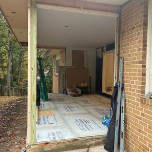 A sliding glass door is being built into a brick house.