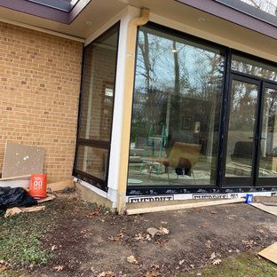 A brick house with a lot of windows and a sliding glass door.