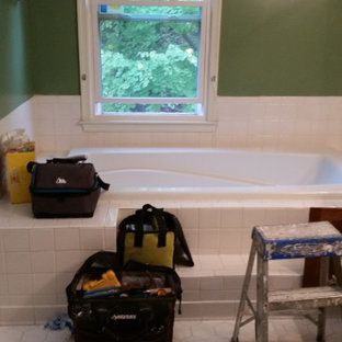 A bathroom with a bathtub , a ladder , and a window.