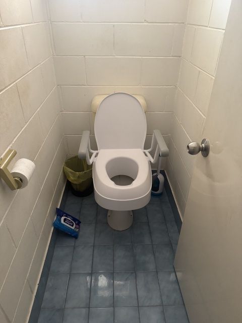 Small Bathroom With a Raised Toilet Seat — Tapped Out Plumbing NT in Bellamack, NT