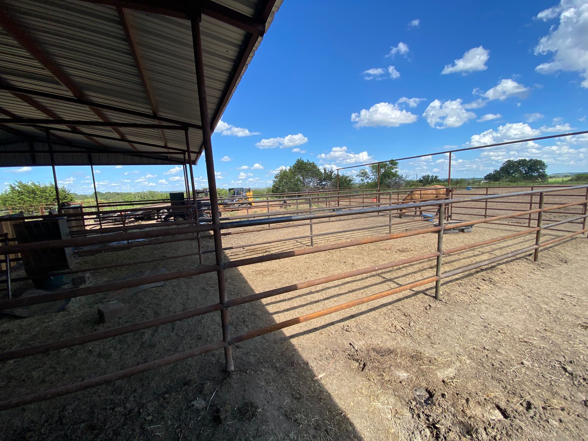 A fenced in area with a shed and a blue sky in the background.