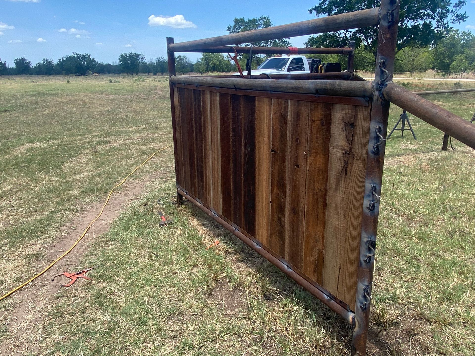 A wooden fence is sitting in the middle of a grassy field.