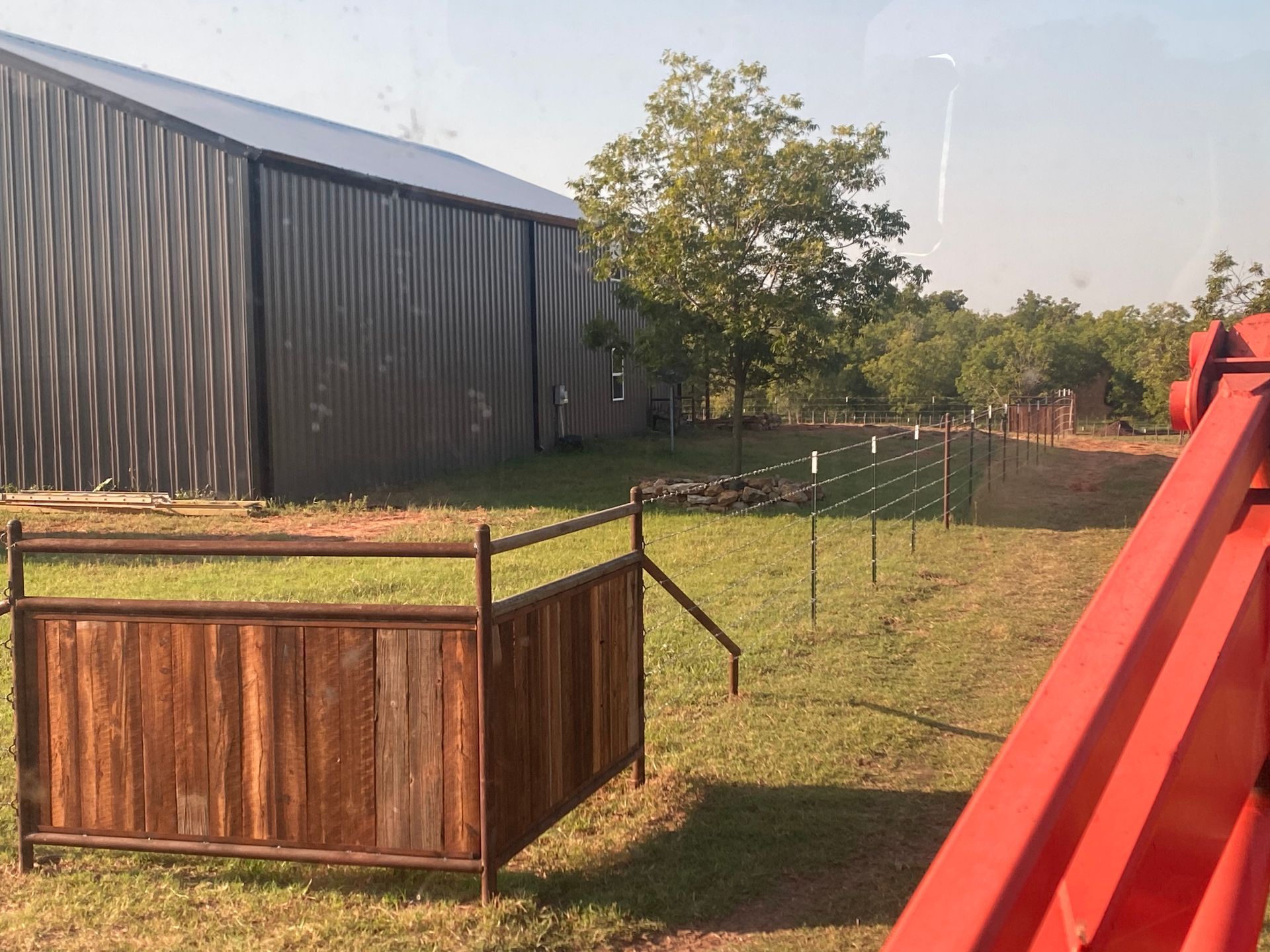 A wooden fence is in the grass in front of a building