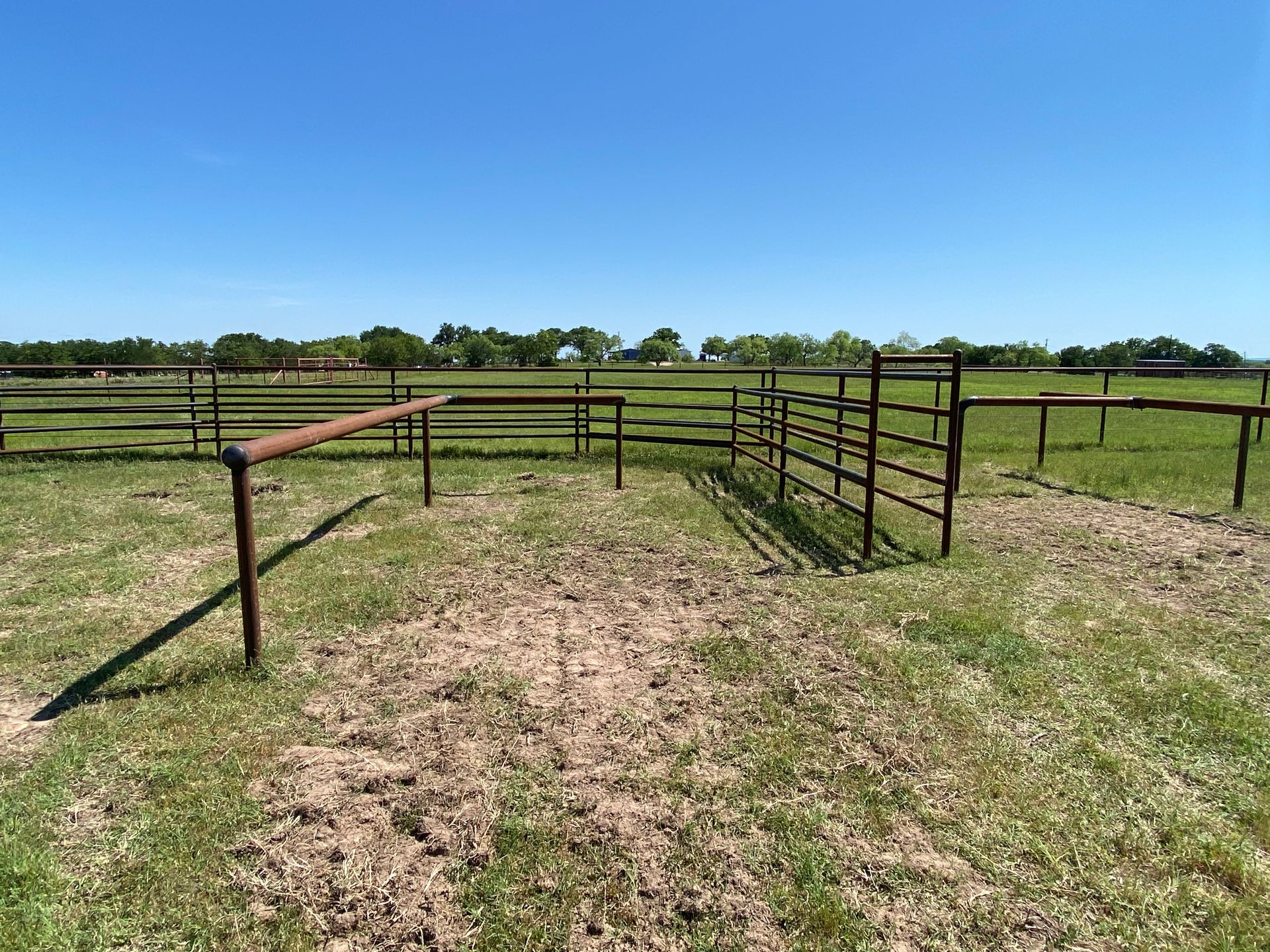 There is a fence in the middle of a grassy field.