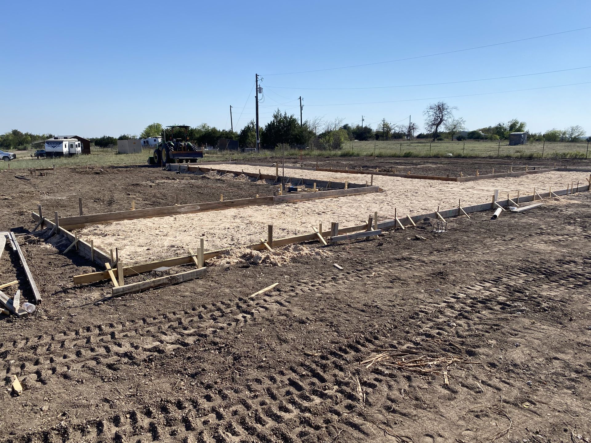 A dirt road is being built in the middle of a field.