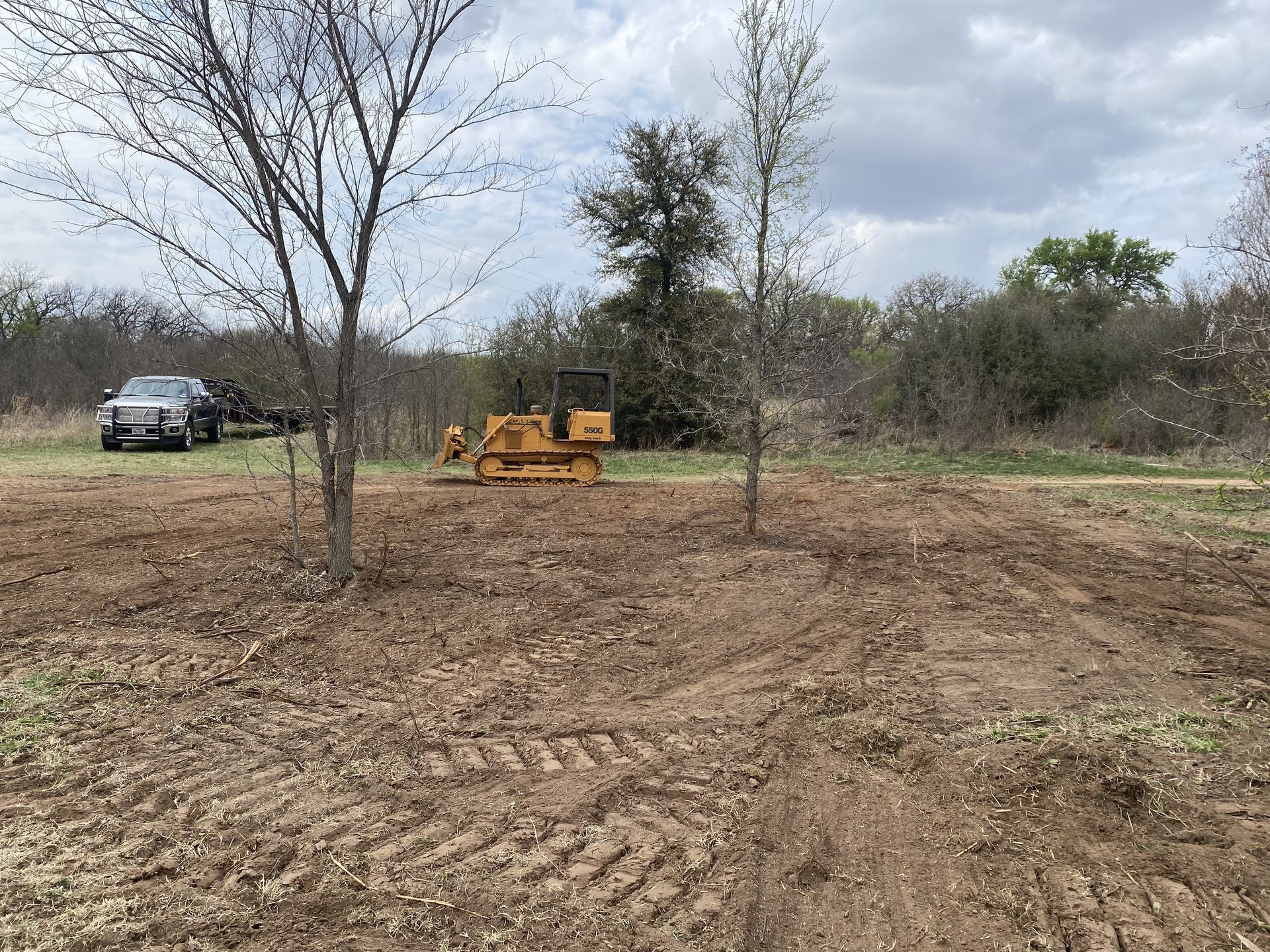 A bulldozer is sitting in the middle of a dirt field.