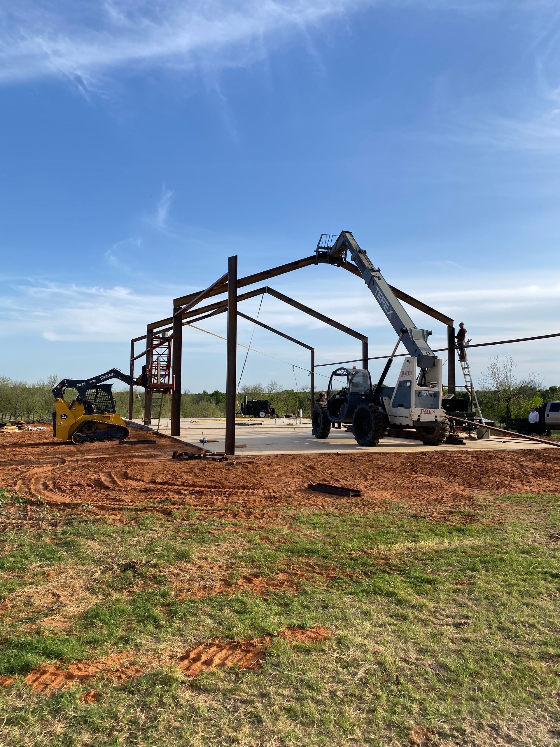A large metal structure is being built in a field.