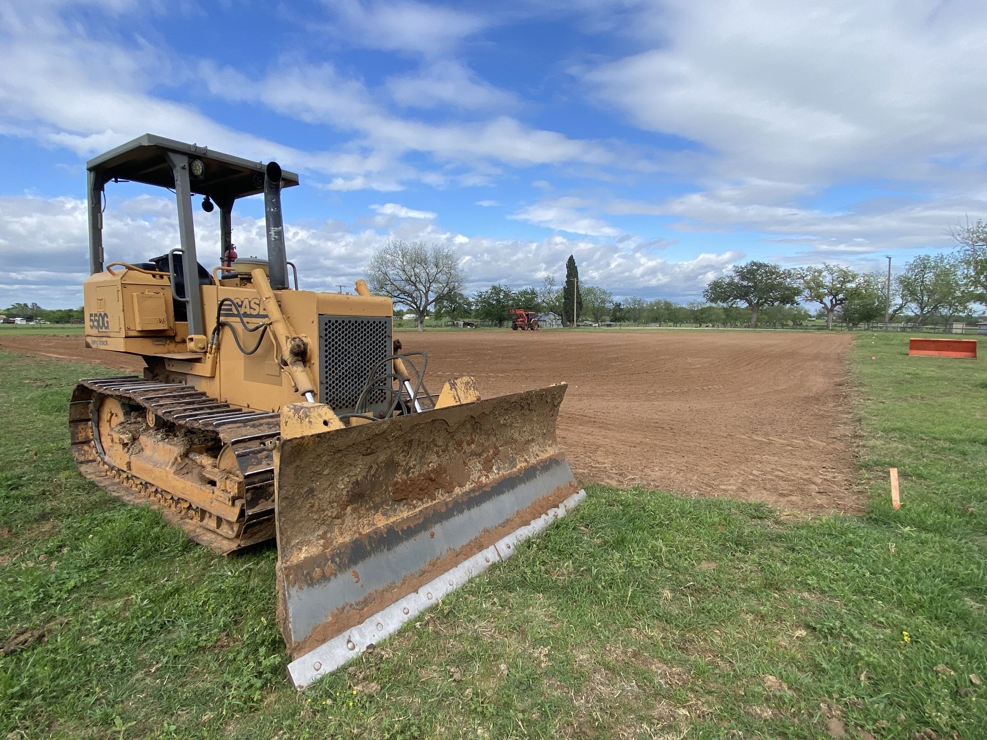 A bulldozer is parked in a grassy field.