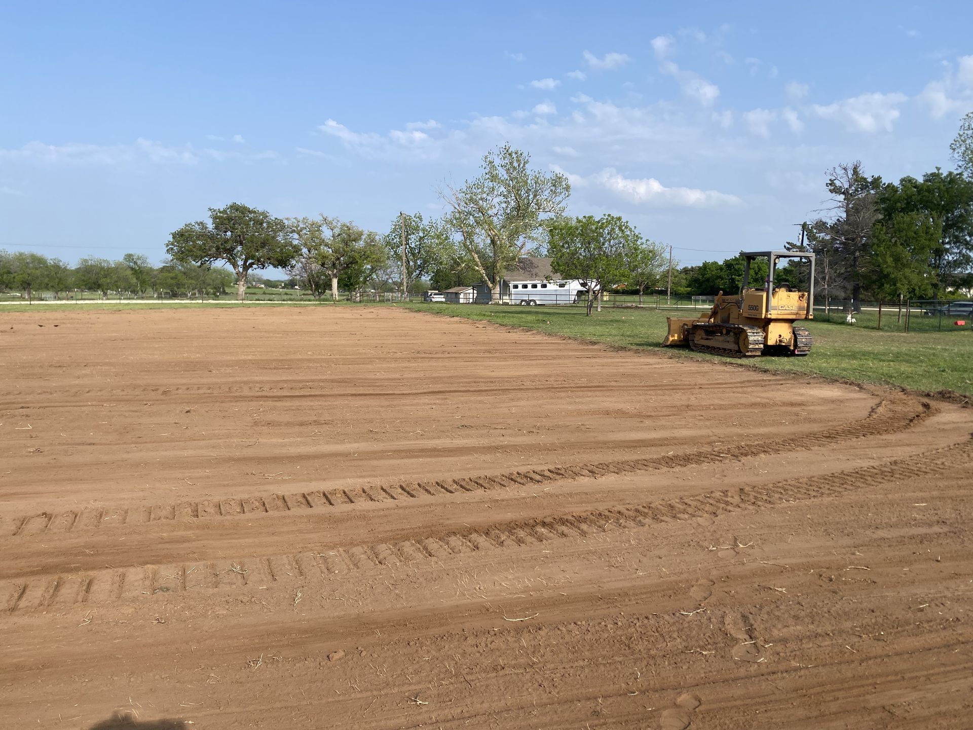 A bulldozer is working on a dirt field.