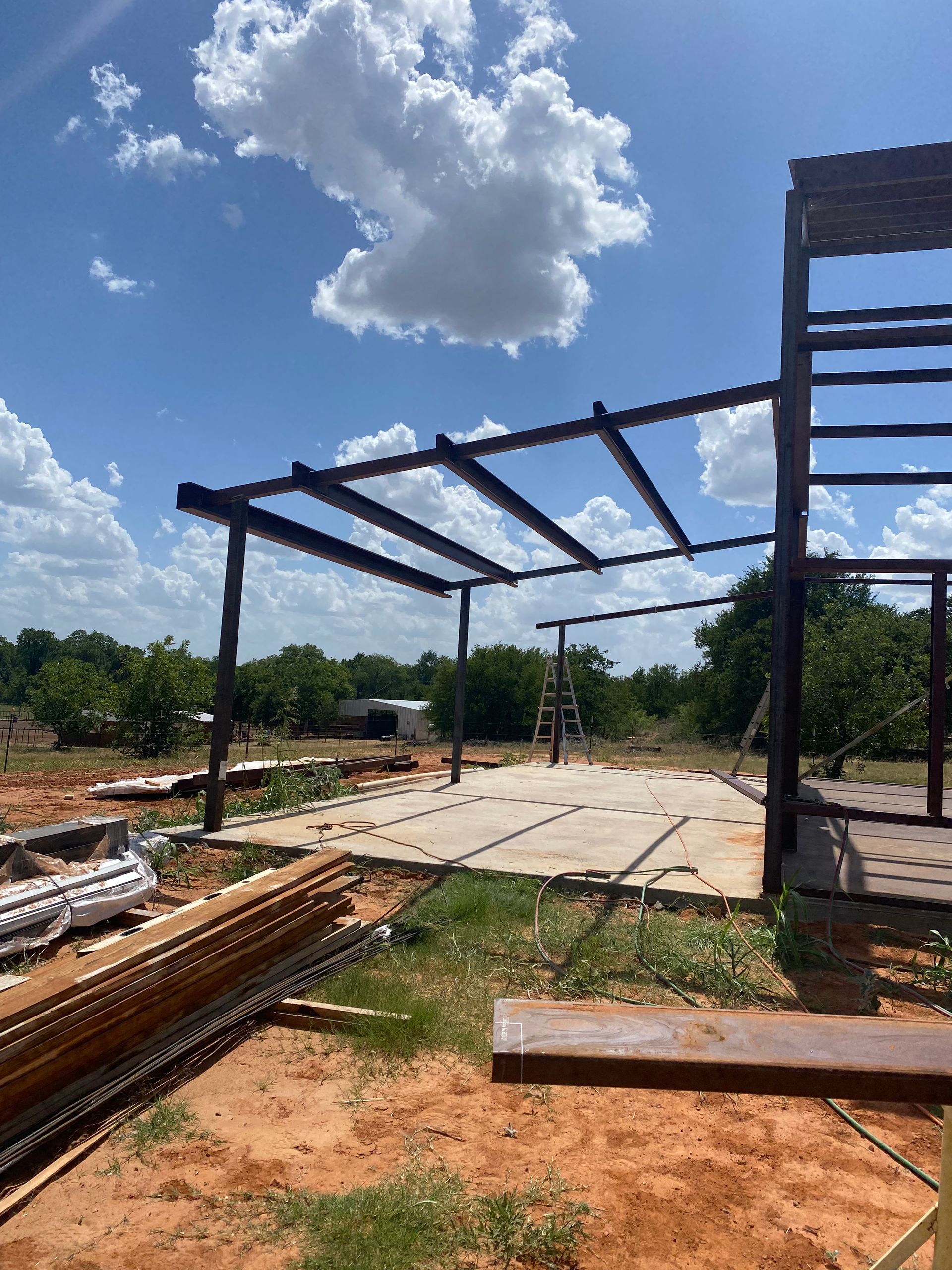 A large metal structure is being built in a field.