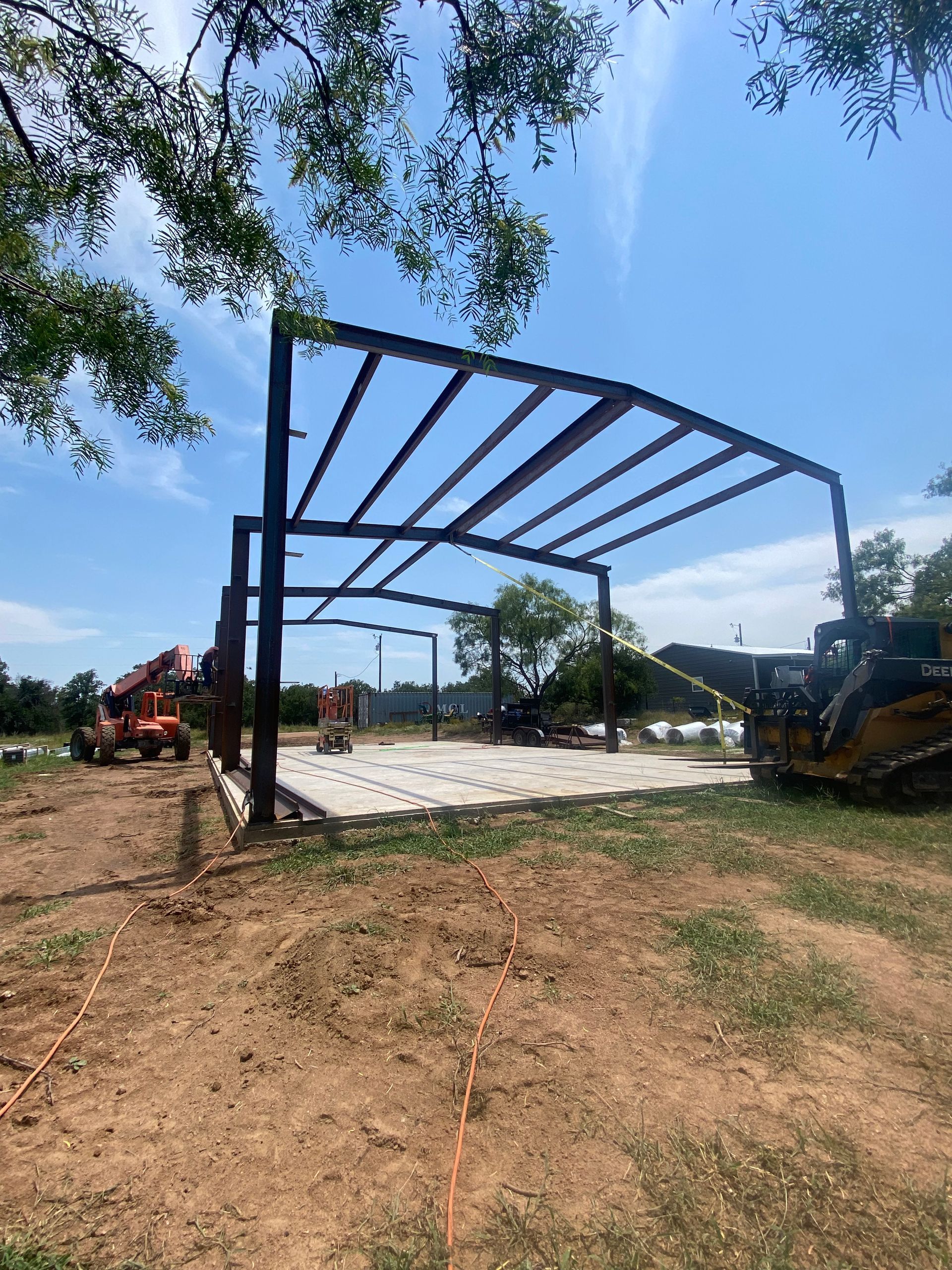 A large metal structure is being built in a field.