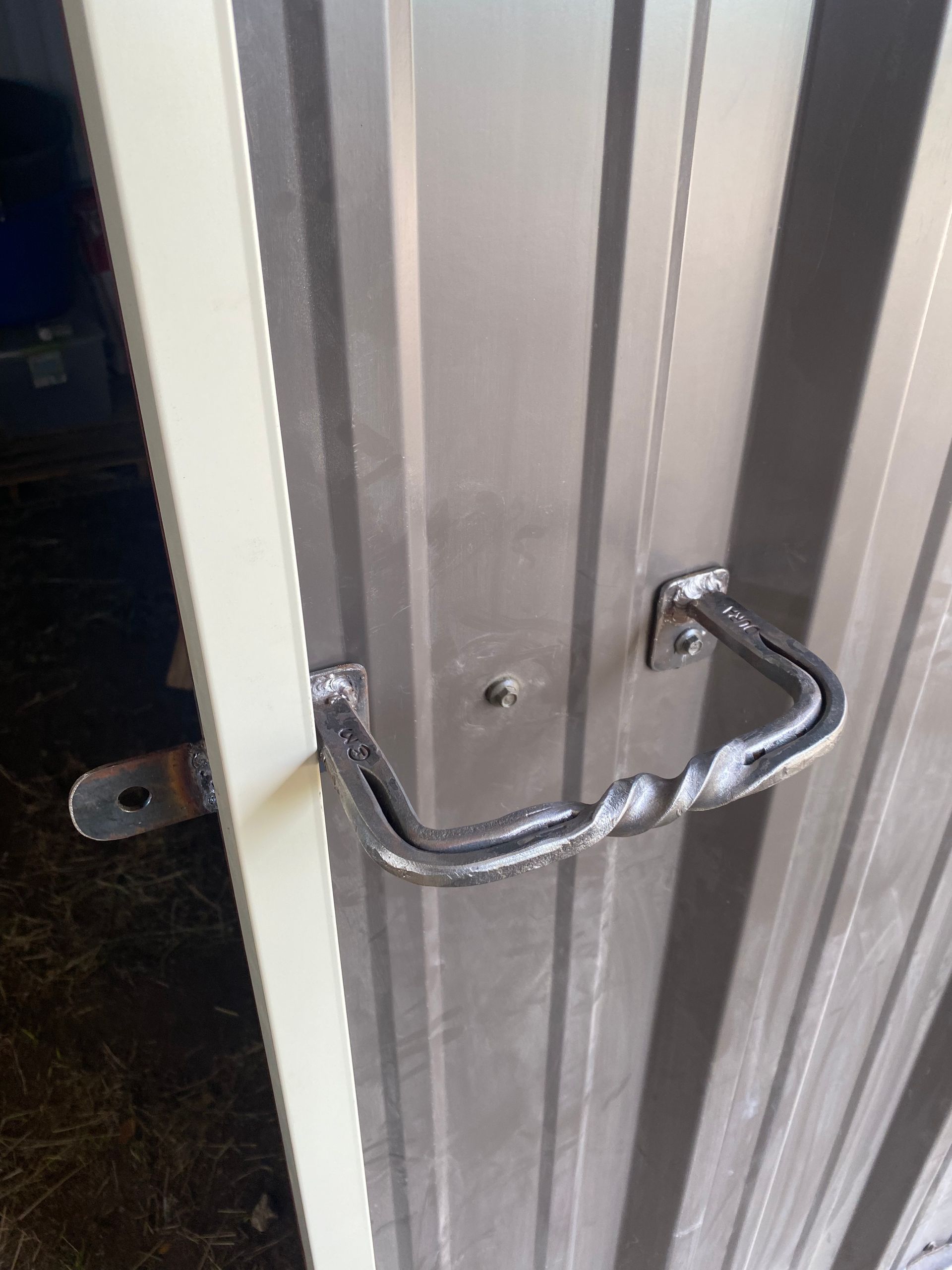 A close up of a metal door with a handle on it.