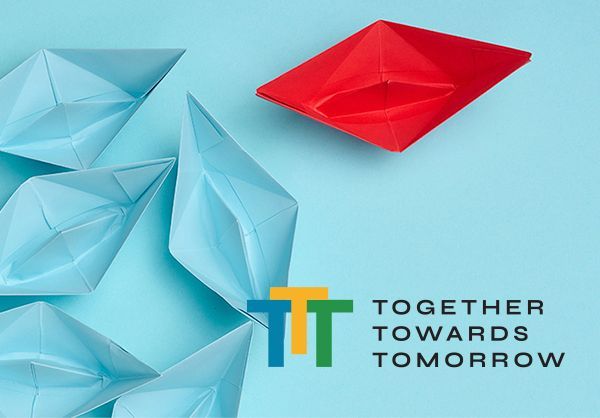 A red origami boat with the words together towards tomorrow below it