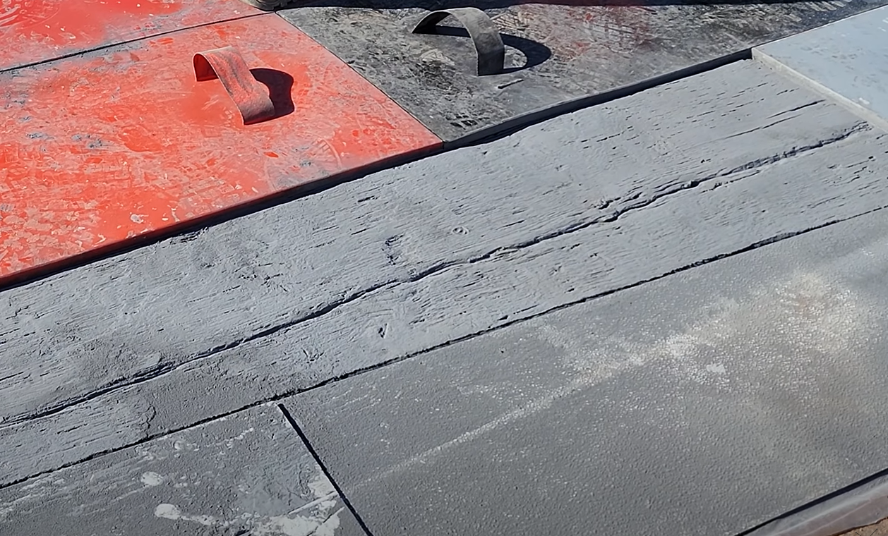 Concrete can be stamped in many designs like this rustic barnwood look.