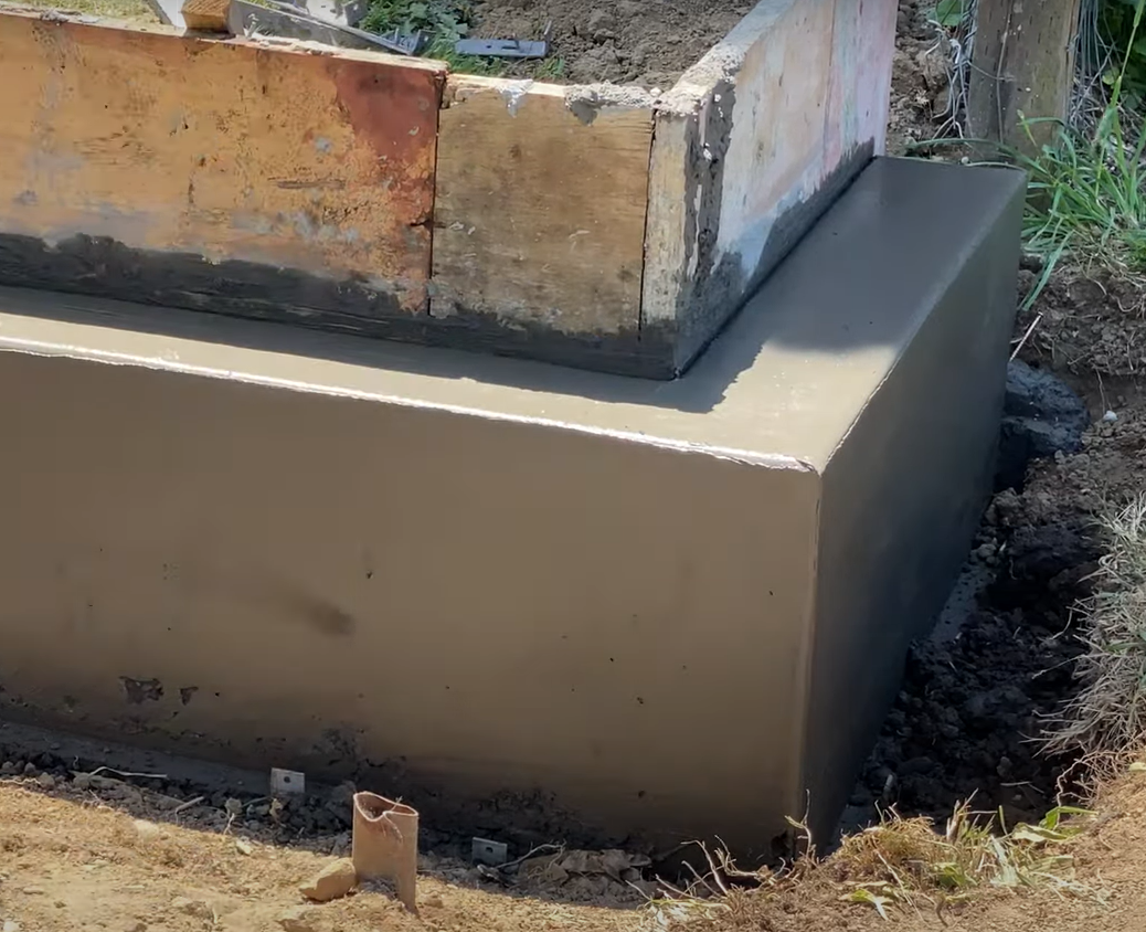 New concrete retaining wall with forms removed and still curing