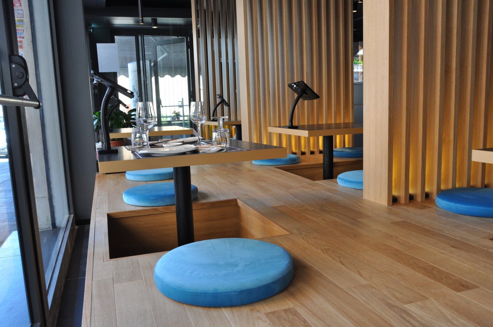 Un ristorante con tavoli e cuscini blu sul pavimento