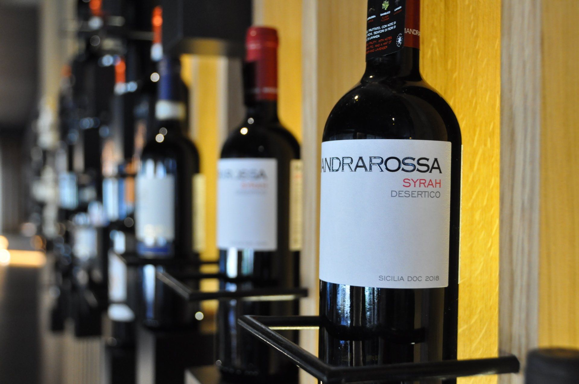 Una fila di bottiglie di vino tra cui una bottiglia di rcrarossa