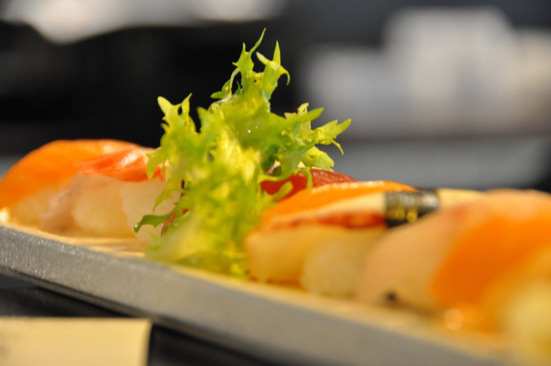 Un primo piano di un piatto di sushi con sopra la lattuga