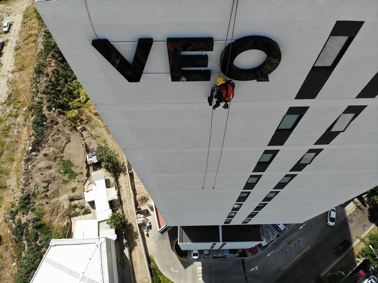Trabajador de acceso por cuerdas limpiando las letras 