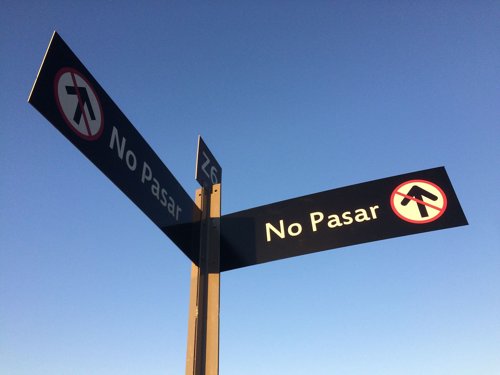 Señales negras con texto blanco y símbolos rojos de 