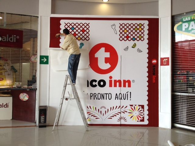 Persona en una escalera instalando un letrero de 