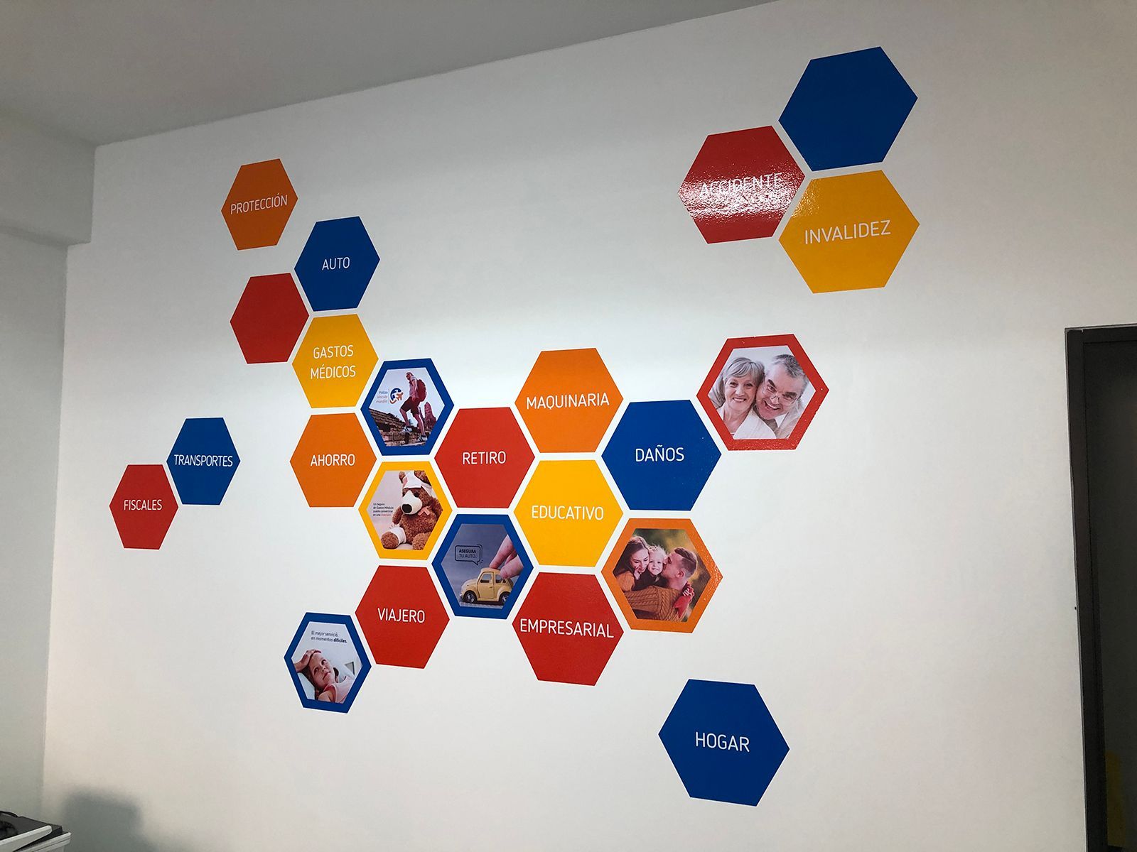 Arte de pared: fotografías y texto en forma de panal en rojo, naranja y azul.